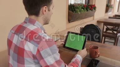 男士手持平板电脑触摸屏，带有用于定制内容的绿屏色度键。男士饮料可与绿屏搭配使用。